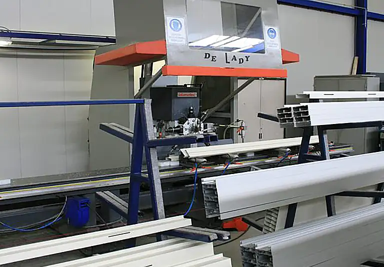 Industrielle Aluminiumprofilbearbeitungsmaschine DE LADY mit weißen Profilen in Werkstatthalle