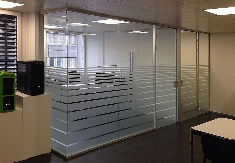 Modernes Büro mit Glastrennwänden und horizontalen Milchglasstreifen, Blick auf Besprechungsraum