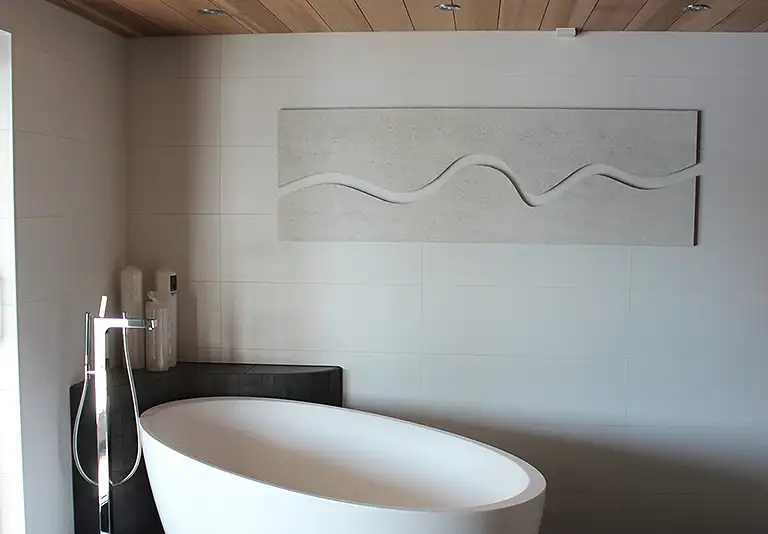 Modernes Badezimmer mit freistehender weißer Badewanne, Holzdecke und schallabsorbierendem Wandrelief mit Wellenform