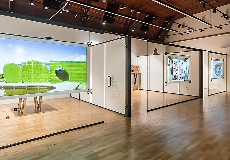 Moderne Galerie mit Glastrennwänden, Smart-i-Wall, Holzboden, großer Videoprojektion einer grünen Landschaft und Kunstwerken
